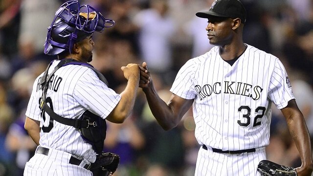 Colorado Rockies relief pitcher LaTroy Hawkins (32) and catcher Wilin Rosario (20) react to the win over the Minnesota Twins at Coors Field. The Rockies defeated the Twins 6-2. 
