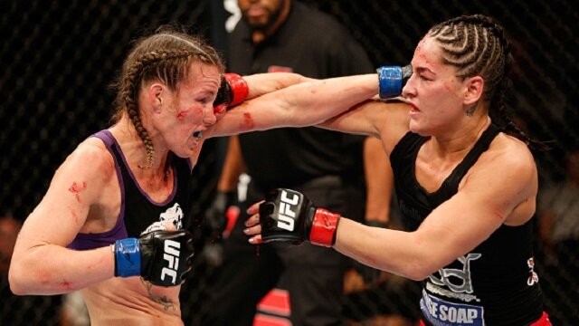 Jessica Eye punches a bloodied Leslie Smith during UFC 180 women's bantamweight clash