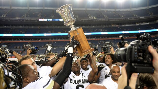 Sep 1, 2013; Denver, CO, USA; Colorado Buffaloes raise the centennial cup following the win over the Colorado State Rams at Sports Authority Field at Mile High. The Buffaloes defeated the Rams 41-27. Mandatory Credit: Ron Chenoy-USA TODAY Sports