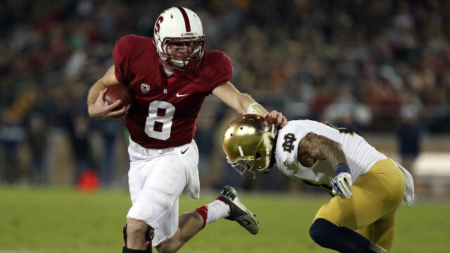 Nov 30, 2013; Stanford, CA, USA; Stanford Cardinal quarterback Kevin Hogan (8) holds off Notre Dame Fighting Irish safety Matthias Farley (41) for a tackle during the third quarter at Stanford Stadium. The Stanford Cardinal defeated the Notre Dame Fighting Irish 27-20. Mandatory Credit: Kelley L Cox-USA TODAY Sports