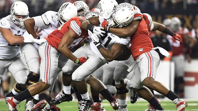 Oregon Ducks running back Royce Freeman (21) is tackled by Ohio State Buckeyes linebacker Raekwon McMillan (2) and linebacker Darron Lee (43) during the second quarter in the 2015 CFP National Championship Game at AT&T Stadium. 