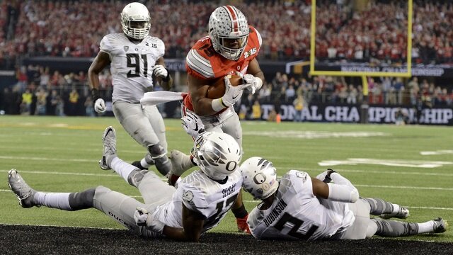 Ohio State Buckeyes running back Ezekiel Elliott (15) runs for a touchdown against Oregon Ducks defensive back Tyree Robinson (2) and defensive back Chris Seisay (12) during the third quarter in the 2015 CFP National Championship Game at AT&T Stadium. 