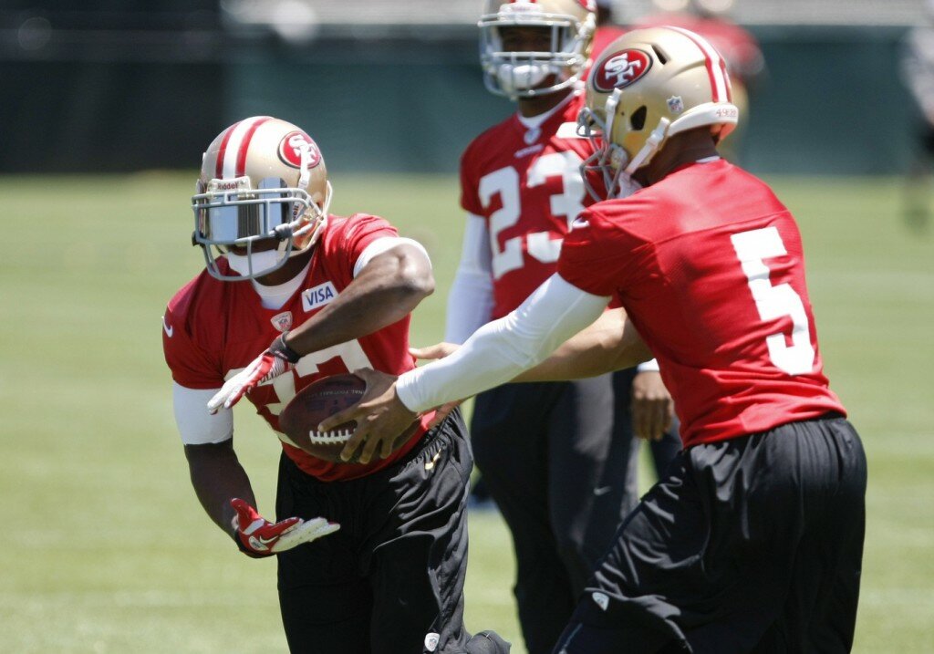 May 22, 2013; Santa Clara, CA, USA; San Francisco 49ers quarterback B.J. Daniels hands off the ball to running back Kendall Hunter (32) during organized team activities at the 49ers training complex. 