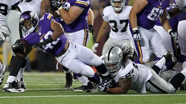 Minnesota Vikings running back Dominique Williams (43) is tackled by Oakland Raiders defensive tackle Torell Troup (64) during the fourth quarter at TCF Bank Stadium. The Vikings defeated the Raiders 10-6. 