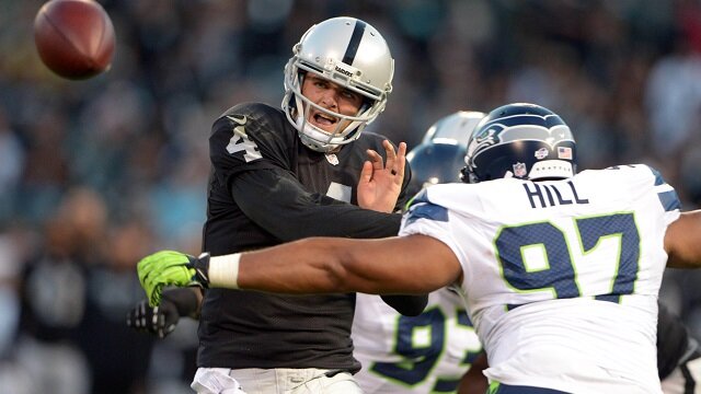 Oakland Raiders quarterback Derek Carr (4) throws a pass under pressure from Seattle Seahawks defensive tackle Jordan Hill (97) at O.co Coliseum