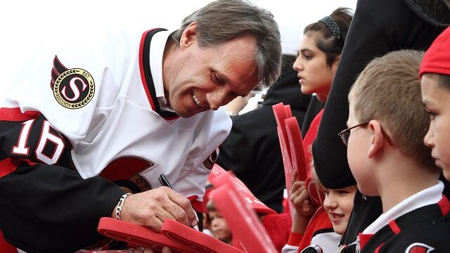 1992-93 Ottawa Senators team member Laurie Boschman signs an autograph on the red carpet, during the 20th anniversary season of the Ottawa Senators pre-game ceremonies prior to the start of the NHL home opener against the Minnesota Wild at Scotiabank Place on October 11, 2011 in Ottawa, Ontario, Canada.