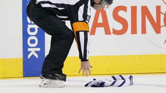 Referee picks up a thrown jersey during a game between Toronto Maple Leafs and Carolina Hurricanes